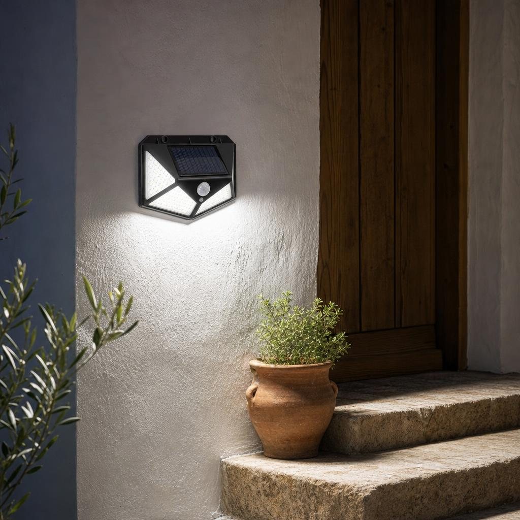 Aplique solar iluminando la entrada de una casa de noche